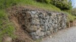 Il a monté son gabion sous le talus en octobre : au printemps suivant, l'oubli d'un détail de paysagiste a fait pencher tout le muret